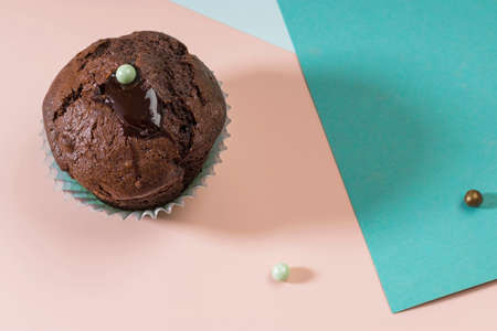 Close-up shot of delicious homemade chocolate muffin with sweets on a pink and blue background. Geometric trend. Creative minimalist food design. Holiday concept. Copy spaceの写真素材
