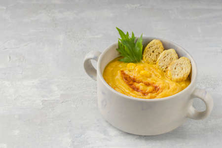 Delicious hot creamy corn soup on a light background. Food for vegans and vegetarians. Healthy diet....