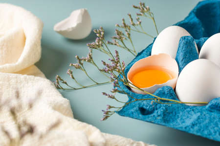 Spring holiday Easter concept. Broken egg with yolk in the shell. Close-up of fresh chicken eggs in...