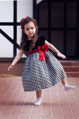 Full body portrait of pretty serious funny girl kid outdoorsの写真素材