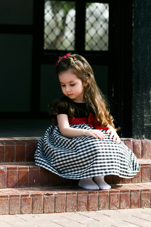 Closeup portrait of pretty serious funny girl kid outdoors summer backgroundの写真素材