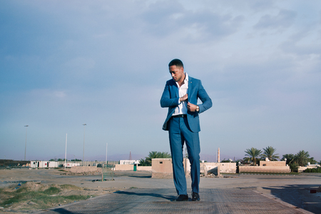 Young handsome man outdoor, wearing suit, walkingの写真素材