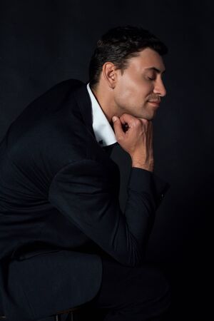 Handsome young man in suit on the black backgroundの写真素材