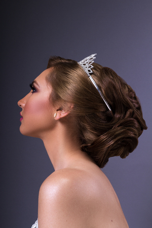 Woman model with bridal make up and hair style, on blue backgroundの写真素材