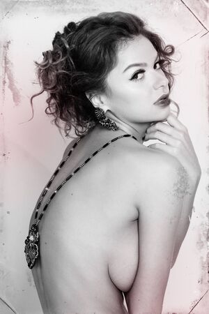 beautiful young woman with curly blond hair and bright makeup. Fashion studio shot. Retro fashion. Black and white imageの写真素材