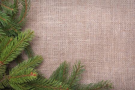 Spruce branches on sackcloth. Christmas frame for the placement of your image.の写真素材