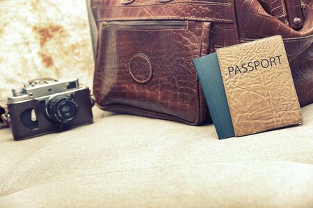 Bag, map, camera and passport on the couch. Toned photo.の写真素材
