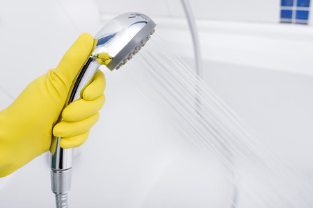 Shower in the hands of cleaning the bathroom.の写真素材