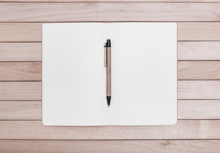 Notebooks and a pen on the background of the wooden planks.の写真素材
