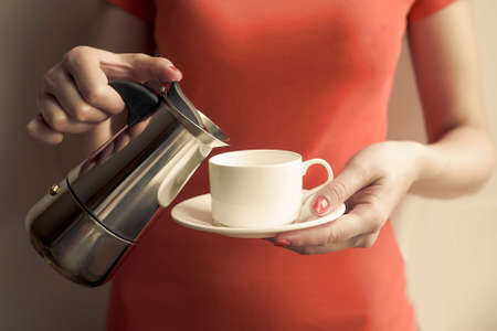 Female hand pours coffee from a the coffee maker. Focus on the hand.の写真素材