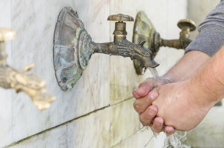 Wash hands in the street under the tap. Close-up.の写真素材