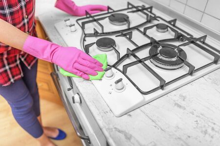 Hands in gloves are washed the gas stove. Close-up.の写真素材