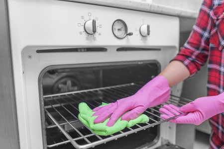 Women washed gloved hands inside oven. Close-up.の写真素材