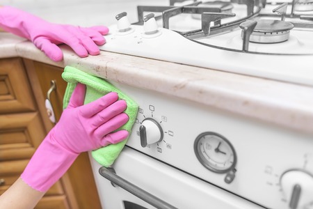 Wash the oven door. Women's gloved hands are washed the dirt.の写真素材