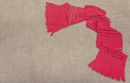 A red scarf on the background of burlap.の写真素材