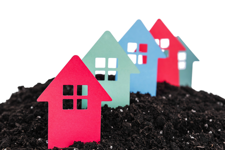 Cardboard houses on a pile of land. Isolated on white background.の写真素材