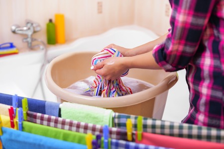Womens hands wash clothes in the basin.の写真素材
