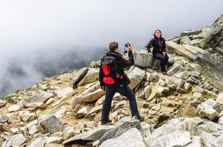 Tourists are photographed in the mountains against the background of rocks.