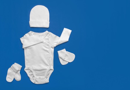 Set of white children's clothes for the little ones on a blue background.の写真素材