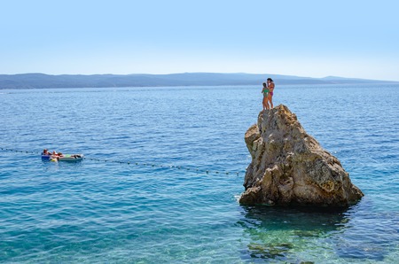 A rocky island in the middle of the Adriatic Sea and resting tourists.のeditorial素材
