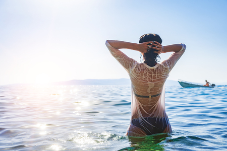 Happy woman enjoying beautiful sunset on the beach.の写真素材