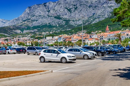 Parking of cars on the city embankment on the background of the mountains.のeditorial素材