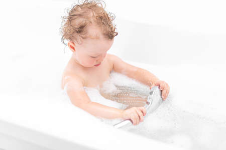 A child girl bathes in a bath.