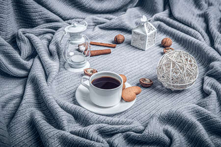 Beautiful plaid, a cup with coffee and cookies on a table with candles.の写真素材