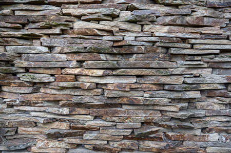 The masonry wall is made of flat stones.
