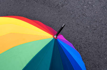 A bright umbrella on the wet asphalt.の写真素材