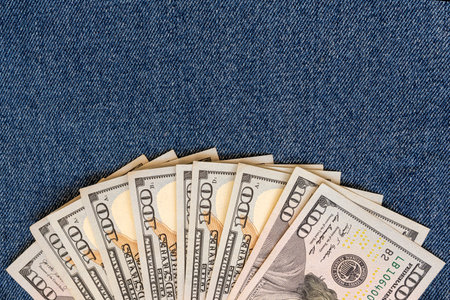 A stack of money on a background of denim.の写真素材