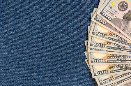 A stack of money on a background of denim.の写真素材