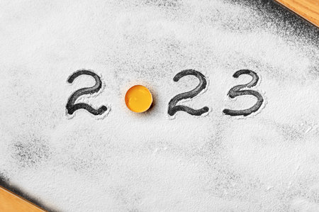 The inscription 2023 on the flour on the kitchen board.の写真素材