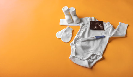 Positive pregnancy test on the background of childrens clothing.の写真素材