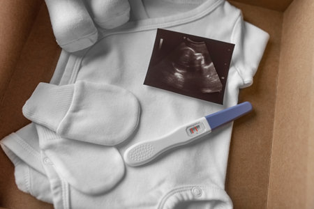 Box with baby stuff and pregnancy test.の写真素材