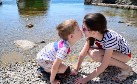 children brother and sister kiss on the beach. boy 5 years. girl 10 years old.