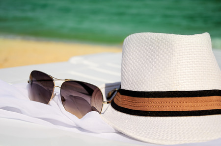 white hat and sunglasses on the background of sea and sand  horizontalの写真素材