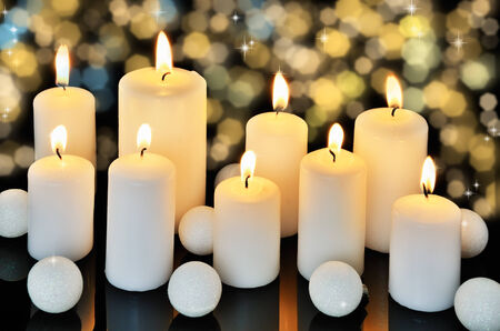 nine burning candles on a dark shiny background horizontalの写真素材