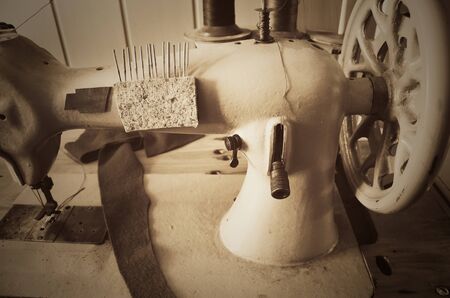 handwheel old sewing machine. horizontal format, sepia, monochrome