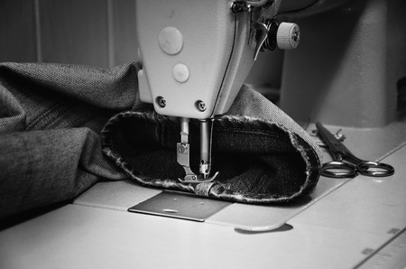 sewing machine and jeans in sewing workshop. monochrome, horizontalの写真素材