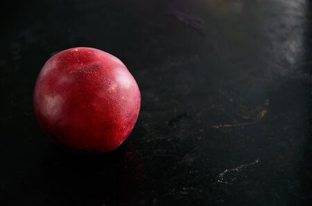 nectarine fruit on a dark background on the left closeup. horizontal, dramatic lighting
