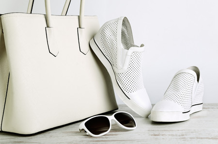 White girls handbag, shoes and sun glasses on a light background horizontalの写真素材