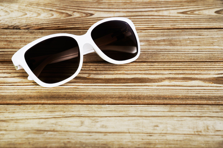 white woman's sunglasses close-up on a wooden background horizontalの写真素材