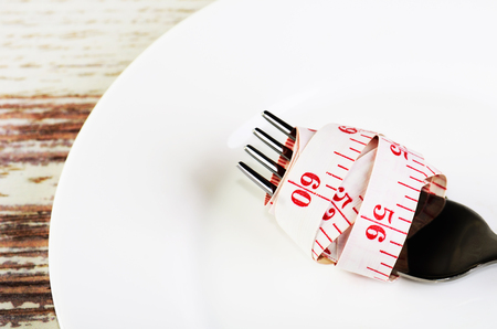 centimeter reeled on a fork in a white plate on a wooden table close-up horizontal formatの写真素材