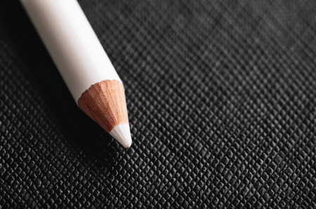 white pencil for french manicure on a black textured background horizontal orientation