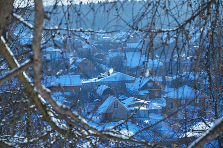 a view of the village through tree branches in winterの写真素材