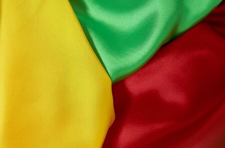 background of red, yellow, green satin fabric with pleatsの写真素材