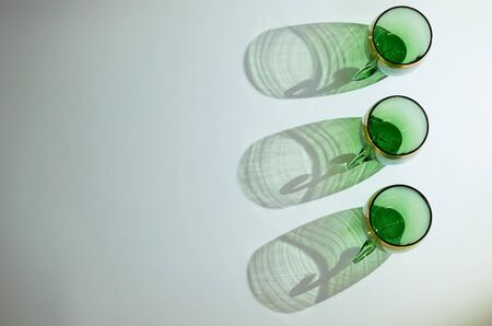 three green glass cups with handles stand in a row on a blue backgroundの写真素材