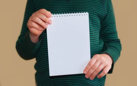 Children's hands hold an empty white envelope. Close up. Space for text