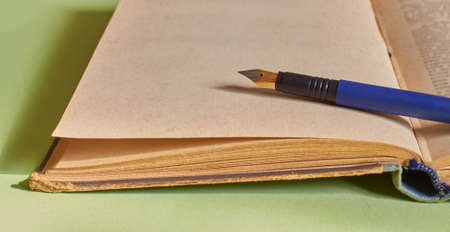 The fountain pen is lying on the open book. Close up. Macro